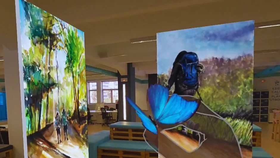 Cuadros flotando en una sala real vistos con gafas de realidad mixta, con una mariposa virtual posada en la mano